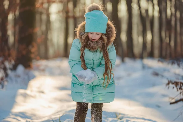在被阳光照亮的冬季森林的背景下的一个女孩的肖像 — 图库照片