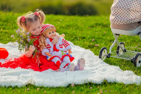 Mädchen Sitzt Mit Ihrer Puppe Auf Einer Decke — Stockfoto