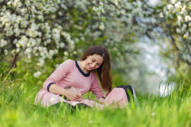 Anne ve kızı açık bir bahçede oturuyorlar.