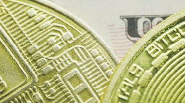 Bitcoin sikkeleri bir dolarlık banknotun üzerine yakın plan yalan söyler.