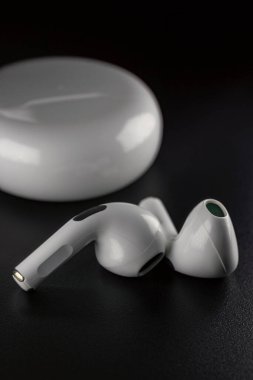 small white headphones on a black background