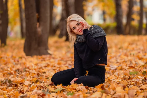 Dziewczyna Blond Włosami Okularami Siedzi Jesiennym Parku — Zdjęcie stockowe