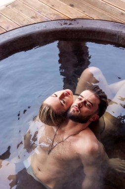 Genç bir çift sırtı su dolu bir fıçıda oturuyor.