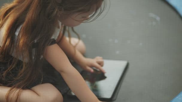 Copilul Stă Trambulină Uită Tabletă Apăsând Periodic Ceva Ecran — Videoclip de stoc
