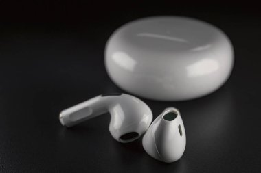 small white headphones on a black background