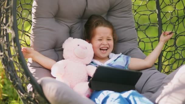 Girl Sits Cocoon Rocking Chair Looks Tablet Nature — Stock Video