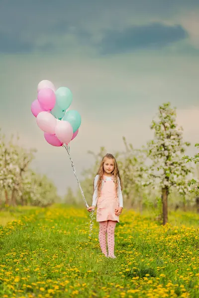 若いリンゴの果樹園で風船を持った少女 — ストック写真