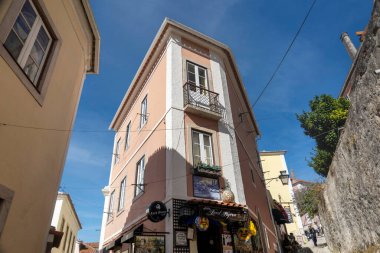 SINTRA, PORTUGAL - 27 Haziran 2022: Restoranlar ve hediyelik eşyalar da dahil olmak üzere Sintra köyünün dar sokakları.