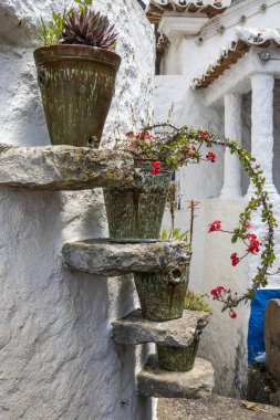 Dört adet sulu bitkilerle dolu demir vazoyu bir evin girişinde kapatın..