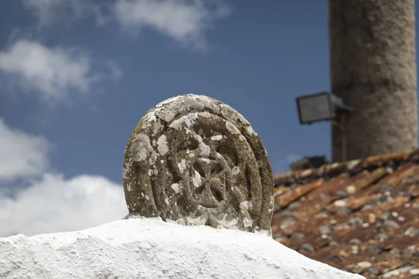 Close up view of a knights templar cross in stone on top of house in Mafra, Portugal.