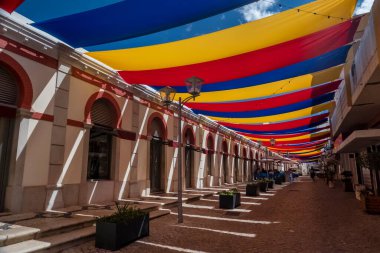 Protection cloth in the street for creating shade in the city of Loule, near the market, in the Algarve, Portugal. clipart