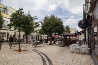 FUSETA, PORTUGAL - 18 Eylül 2022: Kahve dükkanları ve restoranları olan tipik Fuseta köyü merkezi plaza.