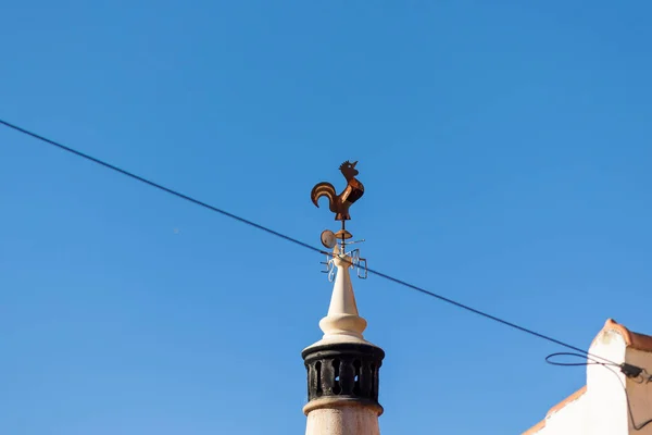 Close view of metal Cock rooster on top of chimney for wind direction.
