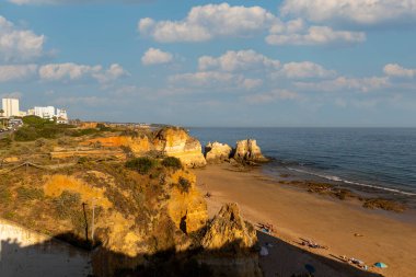 Portimao şehri, Algarve, Portekiz 'deki Careanos plajında günün güzel sonunun görüntüsü.