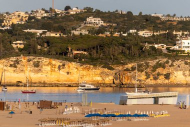 Portimao şehri, Algarve, Portekiz 'deki Rocha plajında günün güzel sonunun görüntüsü.