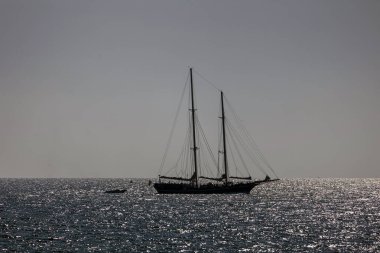 Parlak suyu olan bir yelkenli silueti.