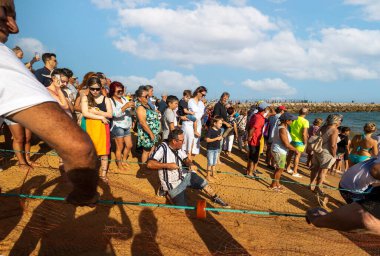 QuARTEIRA, PORTUGAL - 6 HAZİRAN 2023: Plaj kıyısındaki yerel halk tarafından yapılan ağ balıkçılığı geleneği.