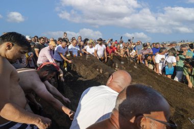 QuARTEIRA, PORTUGAL - 6 HAZİRAN 2023: Plaj kıyısındaki yerel halk tarafından yapılan ağ balıkçılığı geleneği.