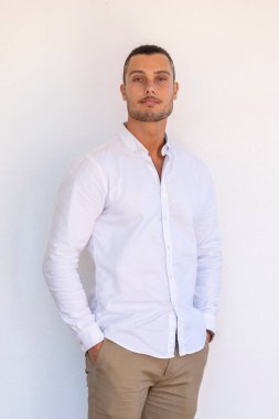 Beyaz arka planda beyaz gömlekli, 20 'li yaşlarının sonlarında beyaz bir adam..