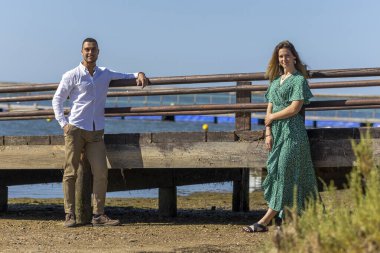 Genç ve mutlu Avrupalı bir çiftin ahşap yolda birbirlerine tutunuşunun yakın görüntüsü.