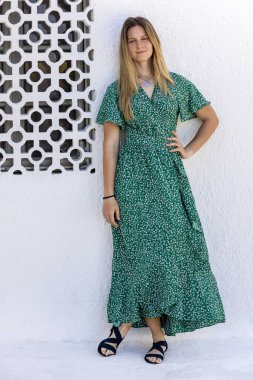 Beyaz arka planda yeşil elbiseli tatlı sarışın kız..