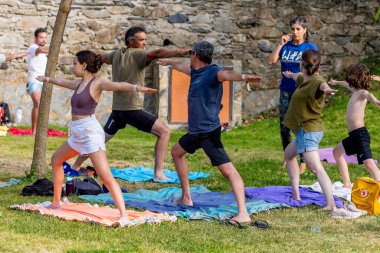 AMEIXIAL, PORTUGAL - 29 Nisan 2023: Bir bahçe üzerinde yoga ve meditasyon egzersizleri yapan grup.