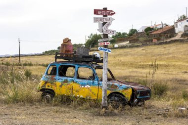 Kırsal kesimde yol kenarında terk edilmiş renkli bir klasik araba..