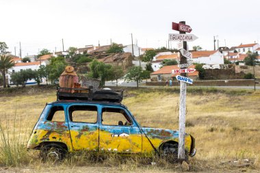 Kırsal kesimde yol kenarında terk edilmiş renkli bir klasik araba..