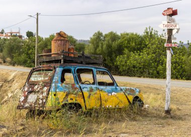Kırsal kesimde yol kenarında terk edilmiş renkli bir klasik araba..