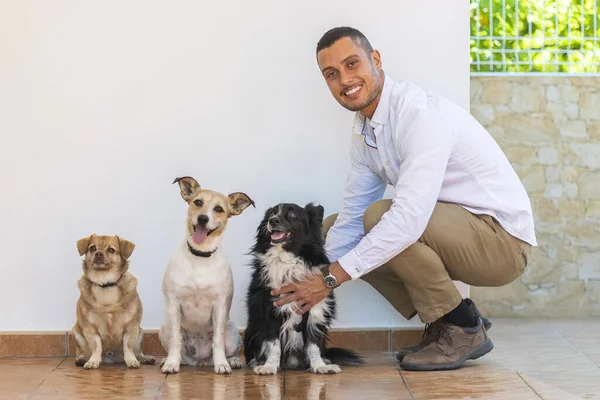 Young man with three puppy dogs over a white background.