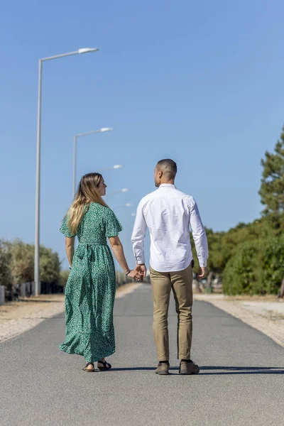 一对快乐的欧洲年轻夫妇在柏油路上紧紧相拥在一起 图库图片