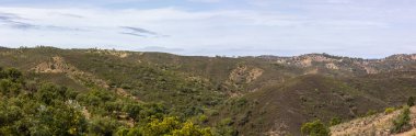 Sao Bras de Alportel yakınlarındaki Algarve bölgesinde Akdeniz manzaralı tepeler.