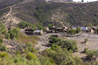 Portekiz 'in Algarve bölgesindeki tepelerde birkaç terk edilmiş ev..