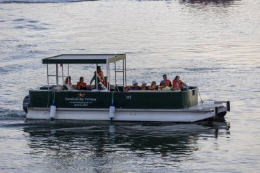 FARO, PORTUGAL - 23 Ağustos 2023: Tekne, Portekiz 'in Faro kenti yakınlarındaki adalar arasında çok sayıda turisti naklediyor.