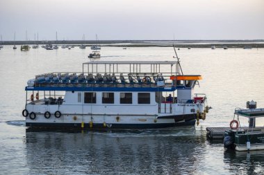 FARO, PORTUGAL - 23 Ağustos 2023: Tekne, Portekiz 'in Faro kenti yakınlarındaki adalar arasında çok sayıda turisti naklediyor.