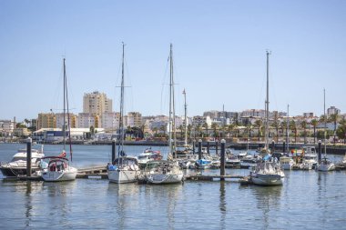 Portimao, Algarve, Portekiz 'de birkaç demirlemiş tekneyle rıhtım manzarası.
