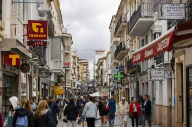 Ronda, İspanya - 20 Ekim 2023: İspanya 'nın Ronda köyündeki Calle La Bola caddesinde yürüyen çok sayıda turist ve müşteriden oluşan bir kalabalık.