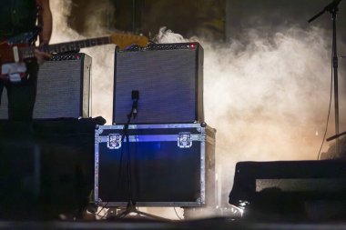 Canlı müzik konseri sahnesinde amfiler ve depolama dahil çeşitli müzik ekipmanları..
