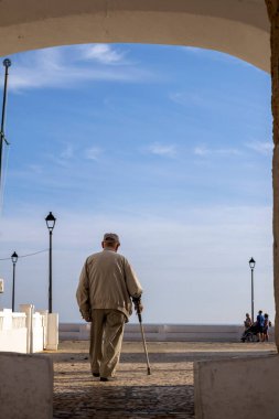 Okyanusu izlemek için yürüyen yaşlı bir adamın yakın görüntüsü..