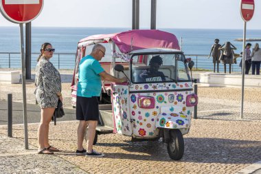 ALBUFEIRA, PORTUGAL - 9 Kasım 2024: Turistler Portekiz 'in Algarve bölgesinde yer alan Albufeira şehrinde süslü bir Tuk Tuk gezisine çıktılar.