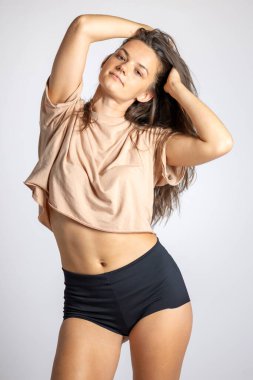 Beyaz arka planda kısa tişörtlü ve siyah şortlu genç şehvetli kadınlar..