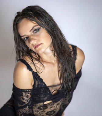 Islak saçlı ve siyah şeffaf vücutlu genç kadınlar. Gri bir arkaplanda.