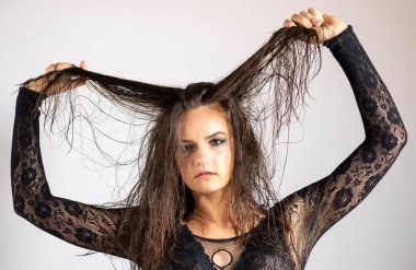 Islak saçlı ve siyah şeffaf vücutlu genç kadınlar. Gri bir arkaplanda.