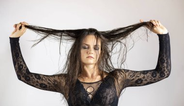 Islak saçlı ve siyah şeffaf vücutlu genç kadınlar. Gri bir arkaplanda.