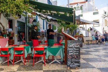 ALBUFEIRA, PORTUGAL - 7 Mayıs 2024: Albufeira şehir merkezi işletmeleri ve barlarda ve restoranlarda iyi vakit geçiren turistler.