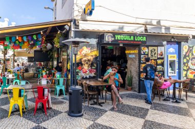 ALBUFEIRA, PORTUGAL - 7 Mayıs 2024: Albufeira şehir merkezi işletmeleri ve barlarda ve restoranlarda iyi vakit geçiren turistler.