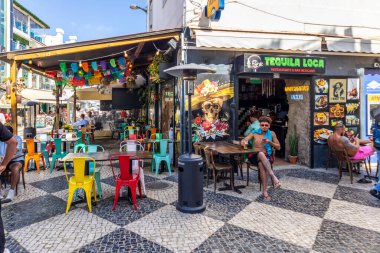 ALBUFEIRA, PORTUGAL - 7 Mayıs 2024: Albufeira şehir merkezi işletmeleri ve barlarda ve restoranlarda iyi vakit geçiren turistler.