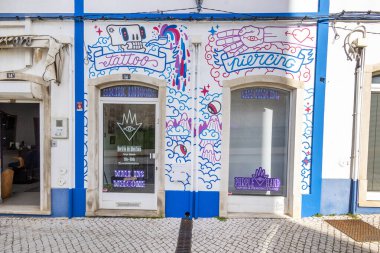 LOULE, PORTUGAL - 17 Mart 2024: Duvarda grafiti ve karalamalar olan küçük dövme işi.