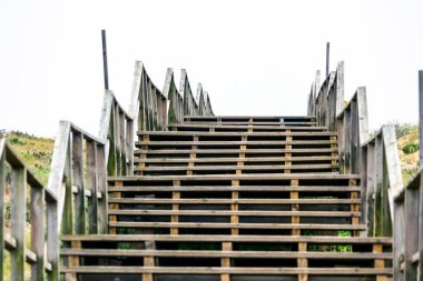 Portekiz 'in Algarve bölgesinde Armacao de Pera yakınlarındaki doğal kum tepecikleri boyunca ahşap yol..