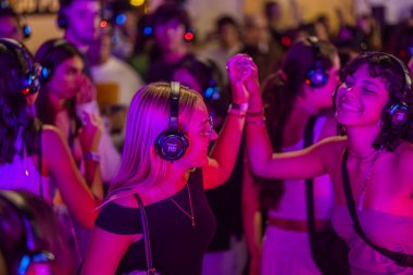 FARO, PORTUGAL: 5 EYLÜL, 2024 - Dinleyiciler F festivalinde kulaklıkla müzik dinliyorlar, sessiz bir disko konsepti..